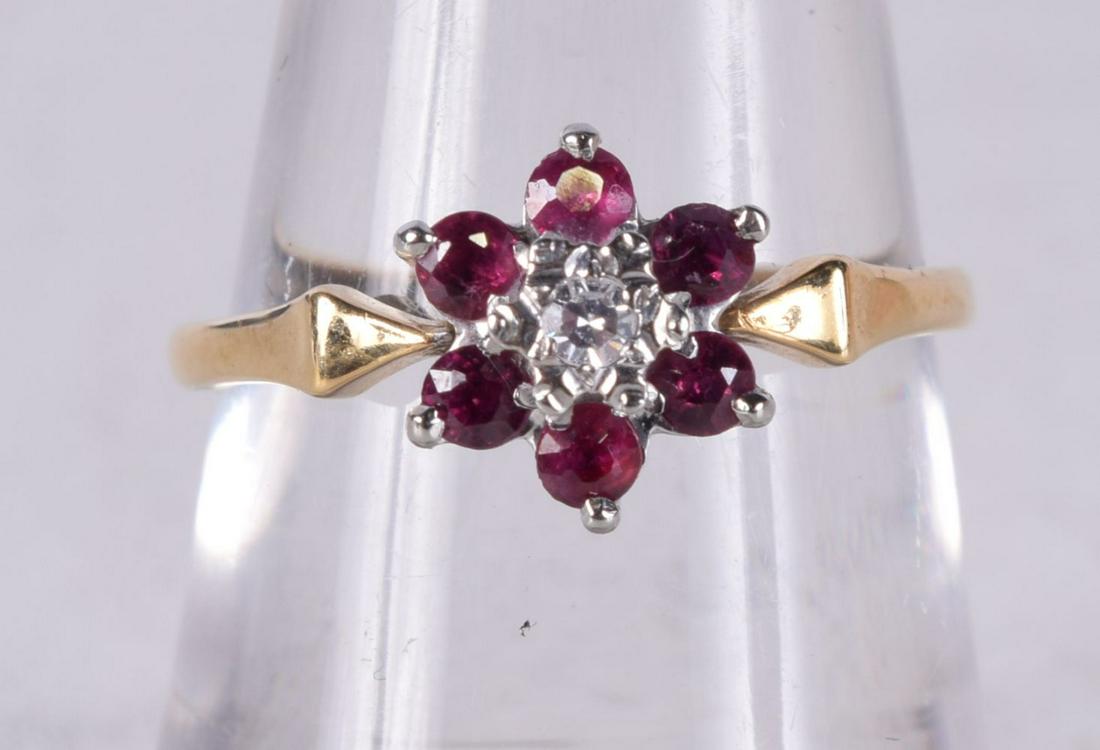 AN 18CT GOLD RING SET WITH A DIAMOND AND SIX RUBIES.  Stamped 18K, Size N, weight 2.3g (1 of 3)