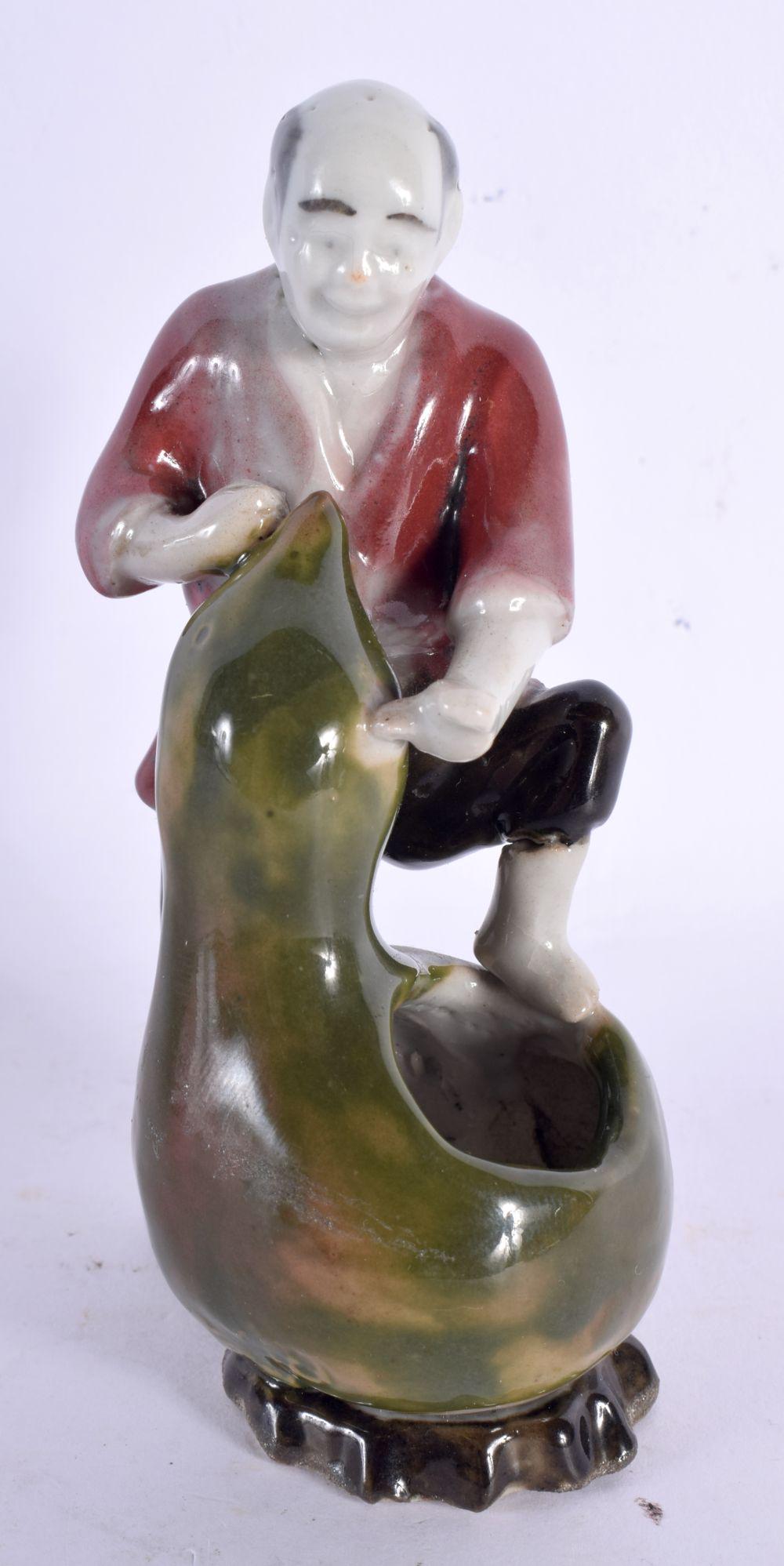 A SMALL EARLY 20TH CENTURY JAPANESE MEIJI PERIOD PORCELAIN FIGURE modelled as a male holding a gourd: A SMALL EARLY 20TH CENTURY JAPANESE MEIJI PERIOD PORCELAIN FIGURE modelled as a male holding a gourd. 12 cm high.