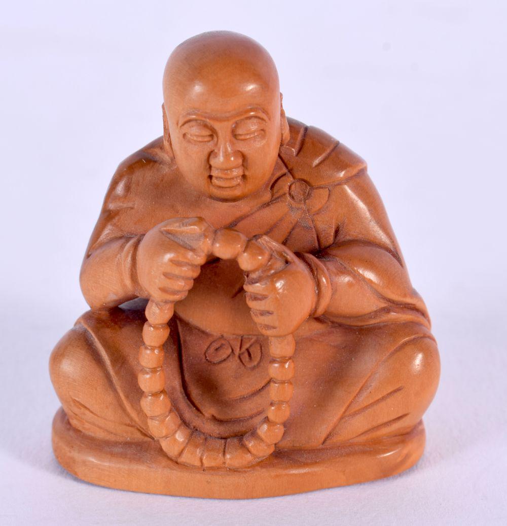 A JAPANESE CARVED BOXWOOD NETSUKE modelled as a monk holding prayer beads. 5 cm x 4 cm.: A JAPANESE CARVED BOXWOOD NETSUKE modelled as a monk holding prayer beads. 5 cm x 4 cm.