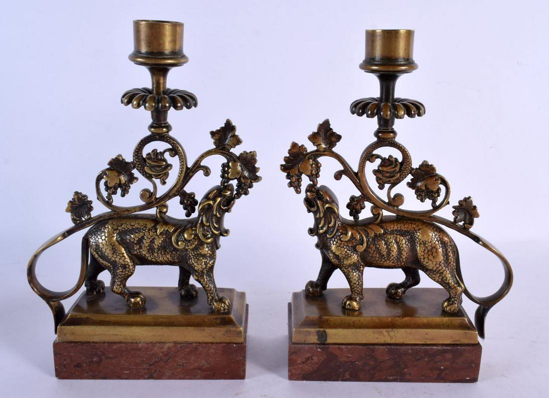 A LOVELY PAIR OF REGENCY BRONZE CANDLESTICKS formed as a beast holding floral sprigs. 20 cm x 12 cm.: A LOVELY PAIR OF REGENCY BRONZE CANDLESTICKS formed as a beast holding floral sprigs. 20 cm x 12 cm.