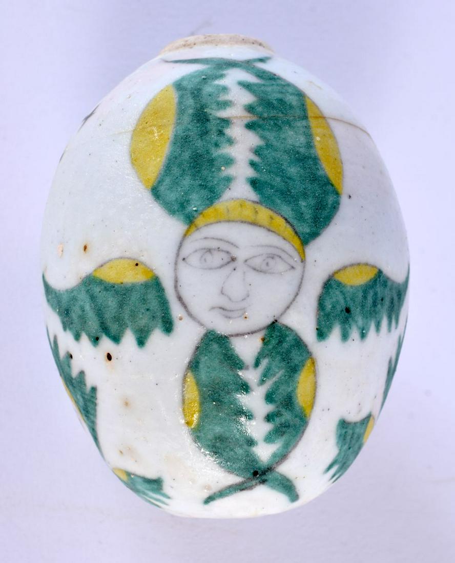 A TURKISH ARMENIAN KUTAHYA POTTERY EGG painted with figures. 9 cm x 7 cm.: A TURKISH ARMENIAN KUTAHYA POTTERY EGG painted with figures. 9 cm x 7 cm.
