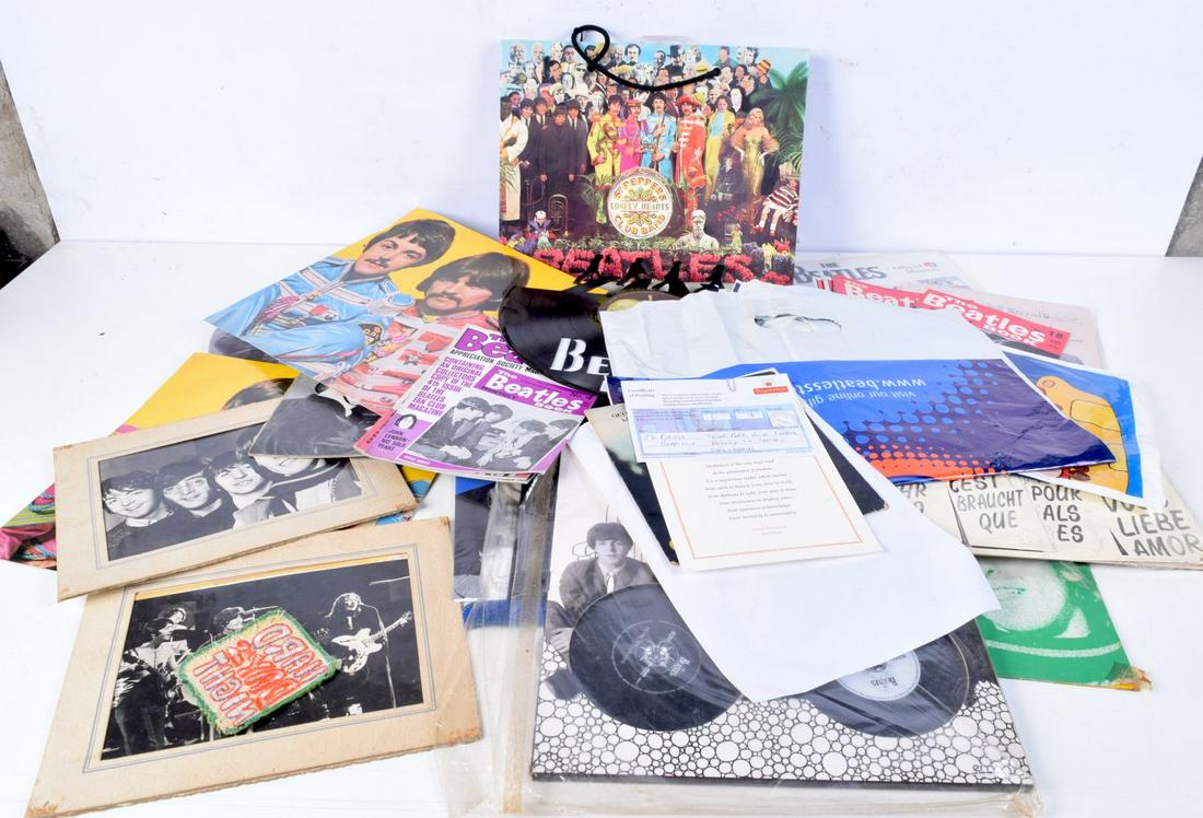 A collection of The Beatles memorabilia including a clock, CDs, fan magazines, carrier bags, picture: A collection of The Beatles memorabilia including a clock, CDs, fan magazines, carrier bags, pictures, etc. (Qty).