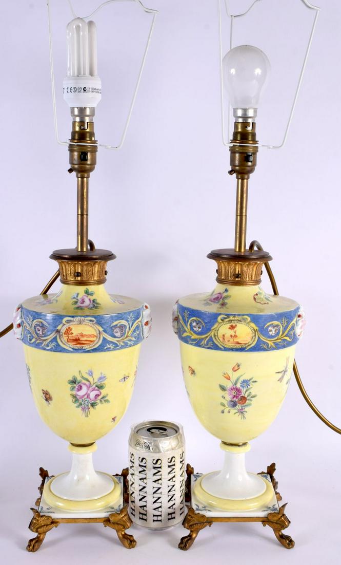 A PAIR OF EARLY 20TH CENTURY CONTINENTAL PORCELAIN LAMPS painted with foliage and landscapes. 55 cm: A PAIR OF EARLY 20TH CENTURY CONTINENTAL PORCELAIN LAMPS painted with foliage and landscapes. 55 cm high.