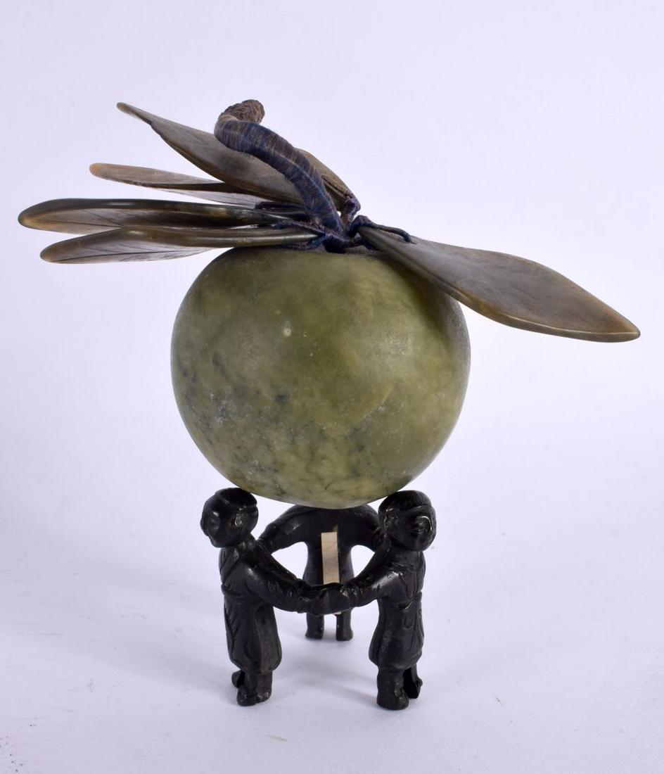 A CHINESE CARVED JADE FRUIT upon a figural bronze base. 12 cm x 12 cm.: A CHINESE CARVED JADE FRUIT upon a figural bronze base. 12 cm x 12 cm.