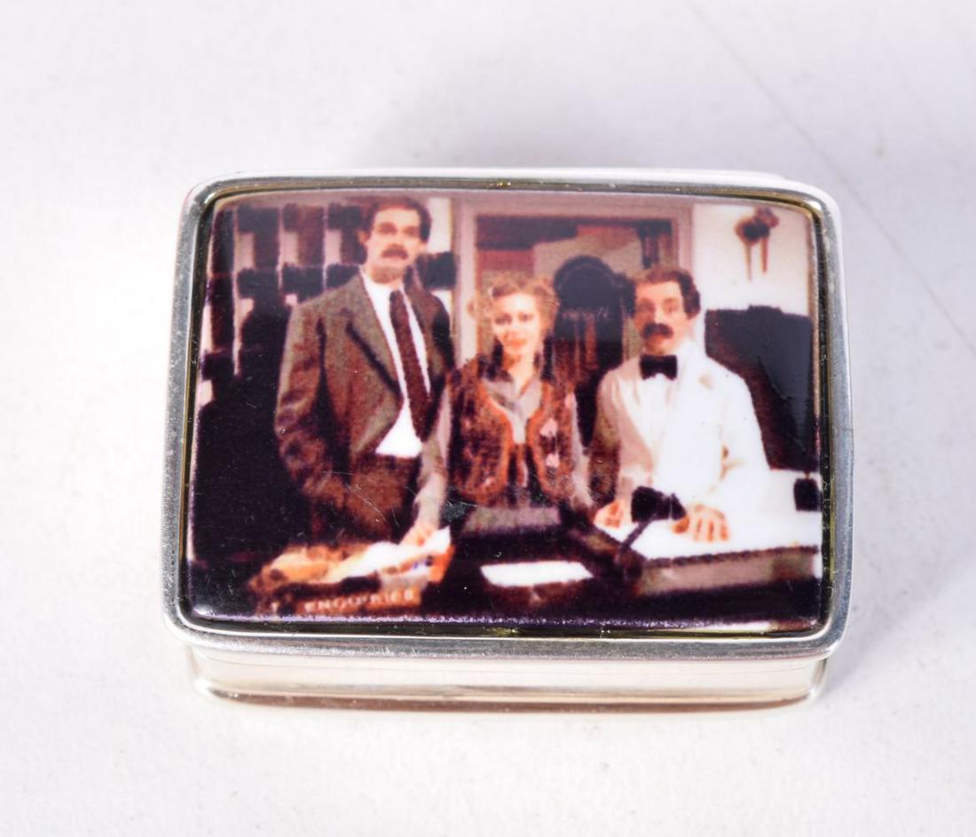 A SILVER PILL BOX WITH LID DEPICTING A SCENT FROM FAWLTY TOWERS. Stamped 925, 1.3cm x 2.6cm x 3.1cm,: A SILVER PILL BOX WITH LID DEPICTING A SCENT FROM FAWLTY TOWERS. Stamped 925, 1.3cm x 2.6cm x 3.1cm, weight 20.1g