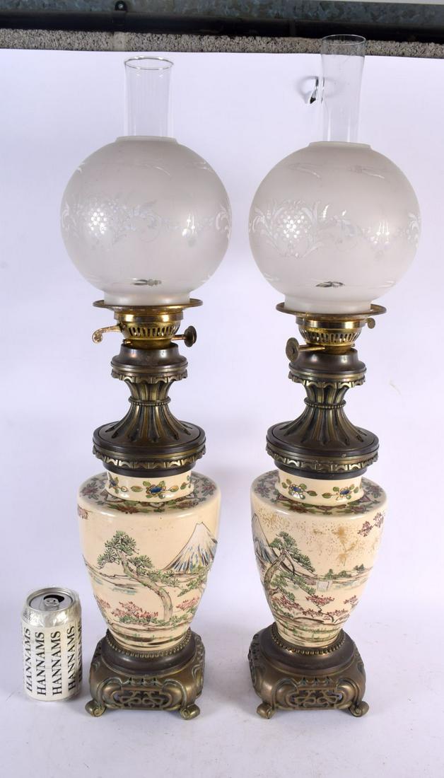 AN UNUSUAL LARGE PAIR OF 19TH CENTURY JAPANESE MEIJI PERIOD SATSUMA OIL LAMPS painted with landscape: AN UNUSUAL LARGE PAIR OF 19TH CENTURY JAPANESE MEIJI PERIOD SATSUMA OIL LAMPS painted with landscapes. 66 cm high.