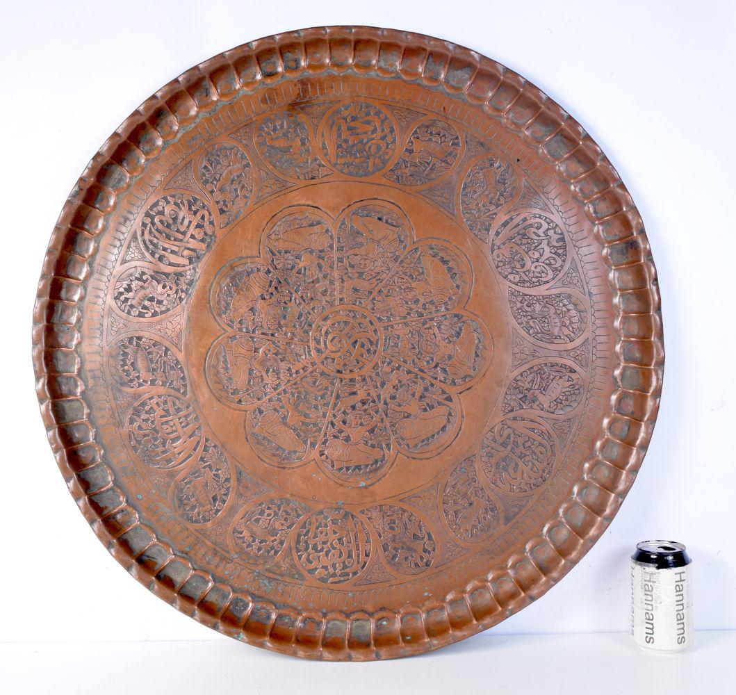 A large Indo-Persian embossed copper tray. 72cm. (1 of 4)