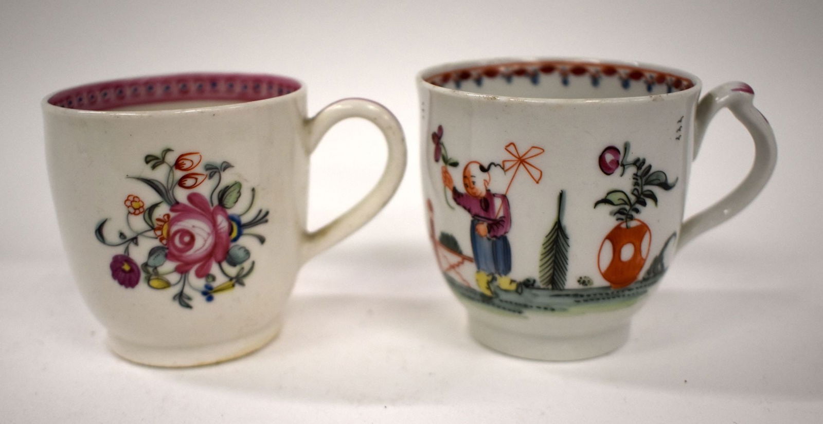 18th-century New Hall coffee cup with clip hand painted with a man with a parasol and a man with a p: 18th-century New Hall coffee cup with clip hand painted with a man with a parasol and a man with a pinwheel and a New Hall cup painted with flowers. Cup 6.5cm high (2)