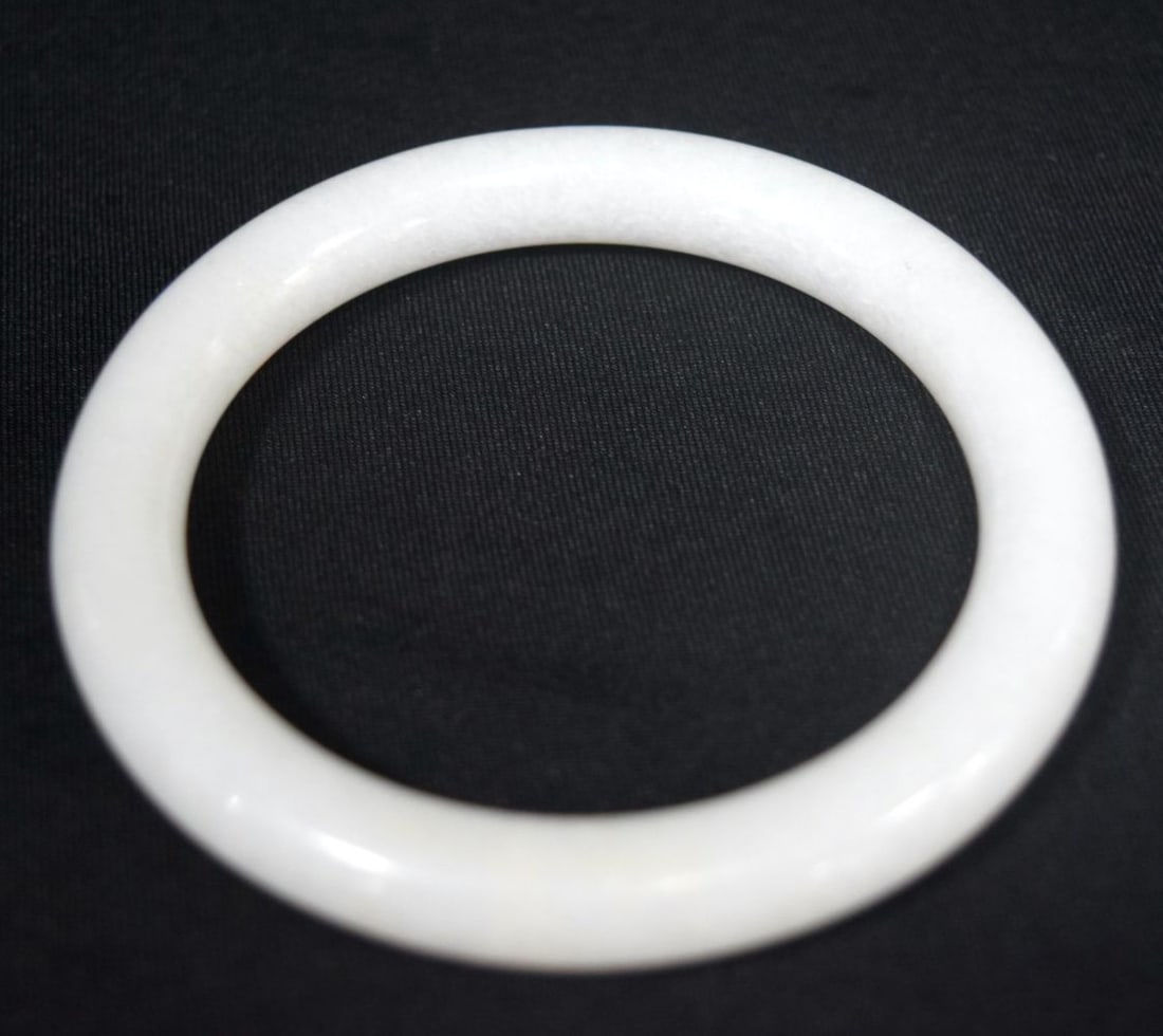 A CHINESE WHITE JADE BANGLE. 47.6 grams. 6 cm diameter.: A CHINESE WHITE JADE BANGLE. 47.6 grams. 6 cm diameter.