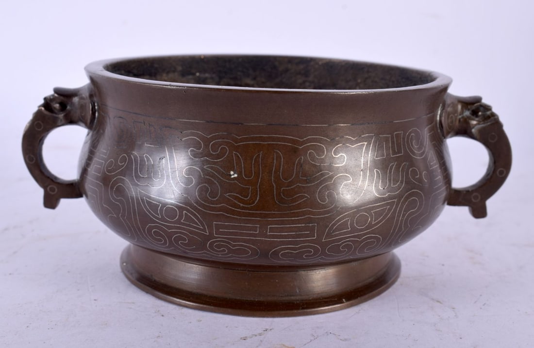 A CHINESE QING DYNASTY SILVER INLAID CENSER decorated with archaic mask heads. 13 cm wide, internal (1 of 6)
