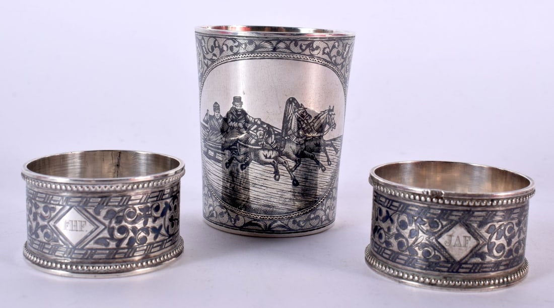 AN ANTIQUE RUSSIAN SILVER NIELLOE BEAKER together with a pair of similar napkin rings. 116.5 grams. (1 of 3)