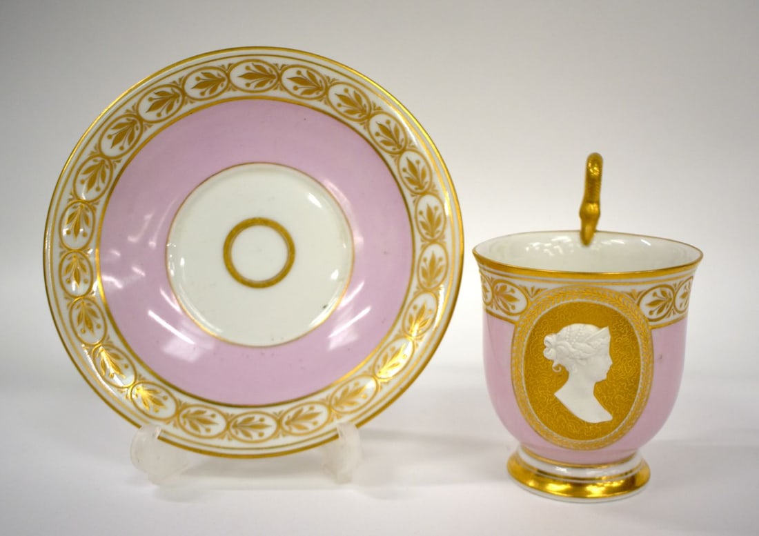 Early 19th century Berlin coffee cup and saucer, with snake handle, the pink ground with gilt oval p: Early 19th century Berlin coffee cup and saucer, with snake handle, the pink ground with gilt oval panel having the profile of Queen Louise of Prussia (1776-1810) in biscuit raised in relief, sceptre 