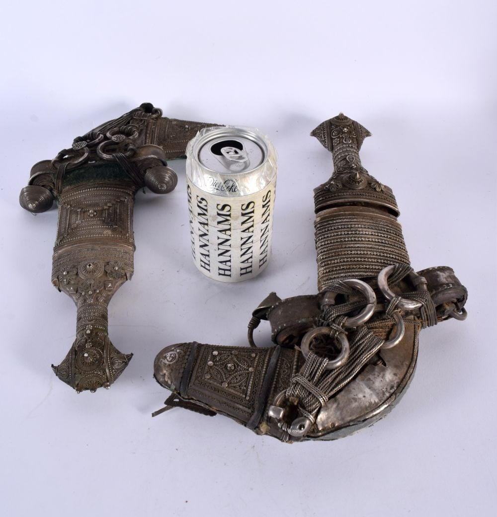 A FINE LARGE NEAR PAIR OF 19TH CENTURY MIDDLE EASTERN OMANI JAMBIYA DAGGERS overlaid in silver work, (1 of 20)