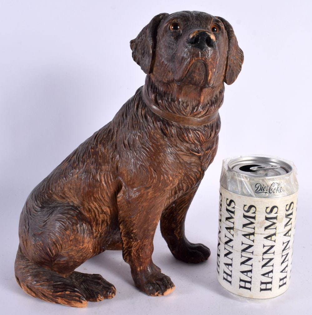 A 19TH CENTURY BAVARIAN BLACK FOREST CARVED WOOD FIGURE OF A HOUND in the manner of Walter Mader, mo: A 19TH CENTURY BAVARIAN BLACK FOREST CARVED WOOD FIGURE OF A HOUND in the manner of Walter Mader, modelled seated with glass eyes. 24 cm x 14 cm. Note: The wood carving industry started out in Switzer