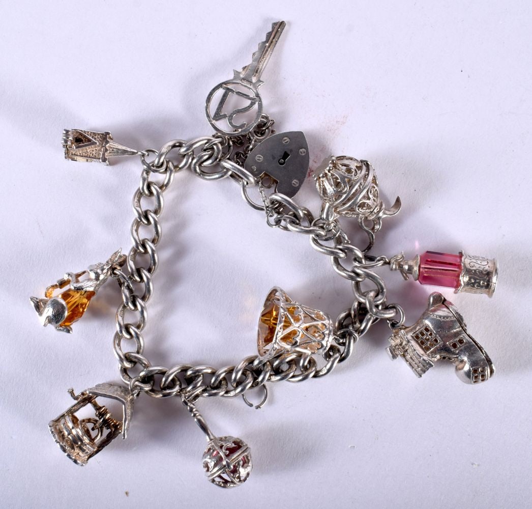 A Silver Charm Bracelet with 9 Charms. Hallmarked London 1972, Length 14cm, weight 52.6g (1 of 5)