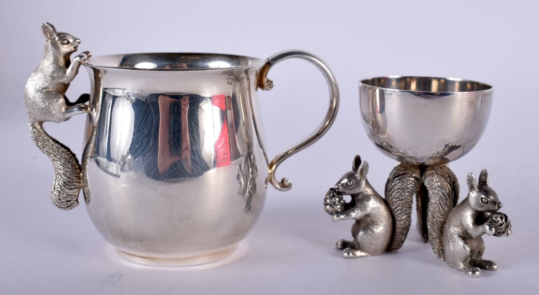 A Silver Mug with a Squirrel climbing on the rim together with a Silver Egg Cup with Squirrel Feet b: A Silver Mug with a Squirrel climbing on the rim together with a Silver Egg Cup with Squirrel Feet by Garrards of London, Hallmarked London 1995. Mug 11cm x 8cm x 6.5cm, total weight 411g (2)