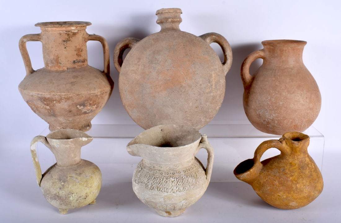 A GOOD COLLECTION OF MIDDLE EASTERN ANTIQUITIES including an iron age C600-700 BC pottery jug, and o: A GOOD COLLECTION OF MIDDLE EASTERN ANTIQUITIES including an iron age C600-700 BC pottery jug, and other similar jugs and flasks, some purchased in Isfanhan Bazaar C1970. Largest 30 cm x 23 cm. (6)