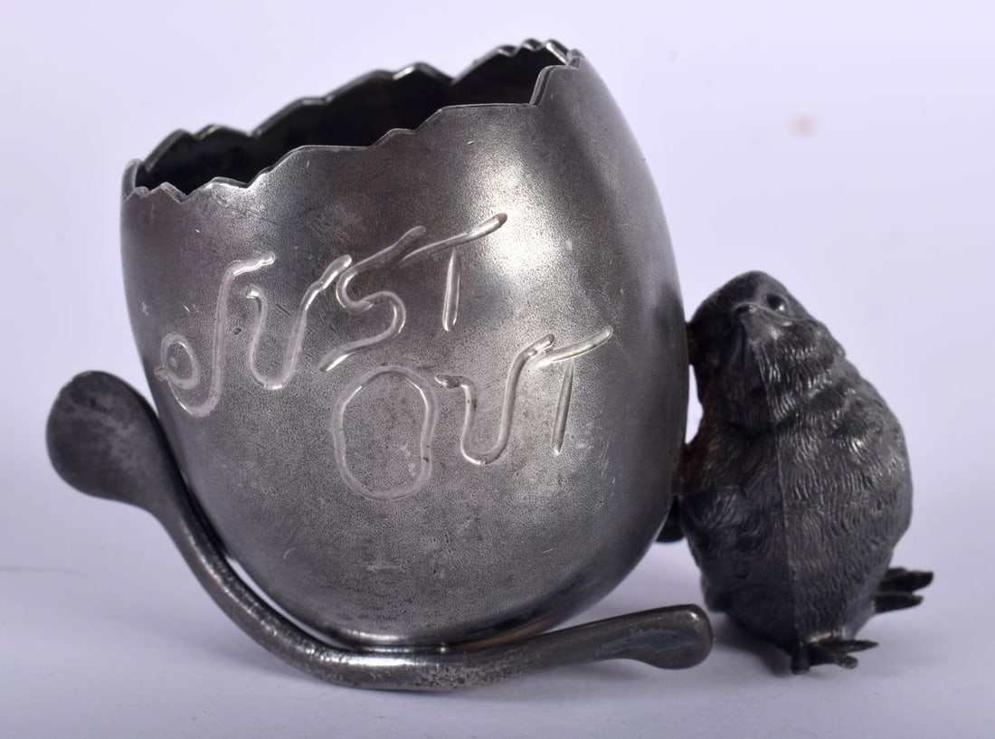 A Novelty Egg Cup modelled as an Egg Balancing on a Wishbone with a Chick. 7.3cm x 5cm x 5cm: A Novelty Egg Cup modelled as an Egg Balancing on a Wishbone with a Chick. 7.3cm x 5cm x 5cm