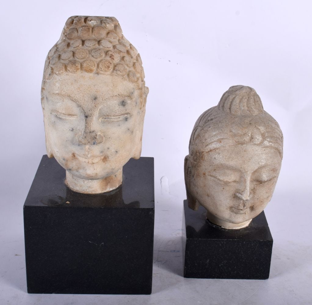 TWO CHINESE QING DYNASTY CARVED STONE HEADS OF BUDDHA modelled with sureen expressions. Largest 23 c (1 of 6)