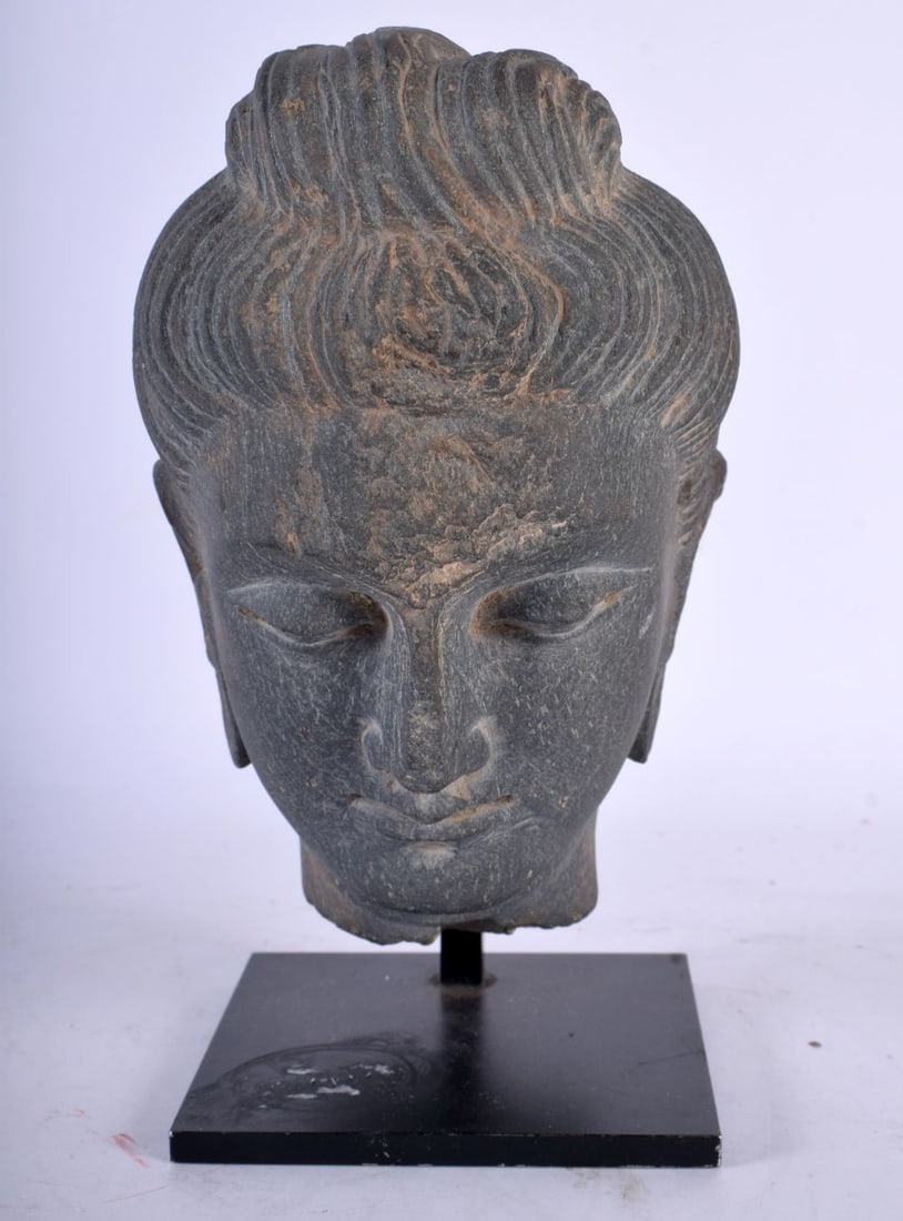 A grey Schist buddha head, face with peaceful expression, heavy lidded almond-shaped eyes downcast i (1 of 4)
