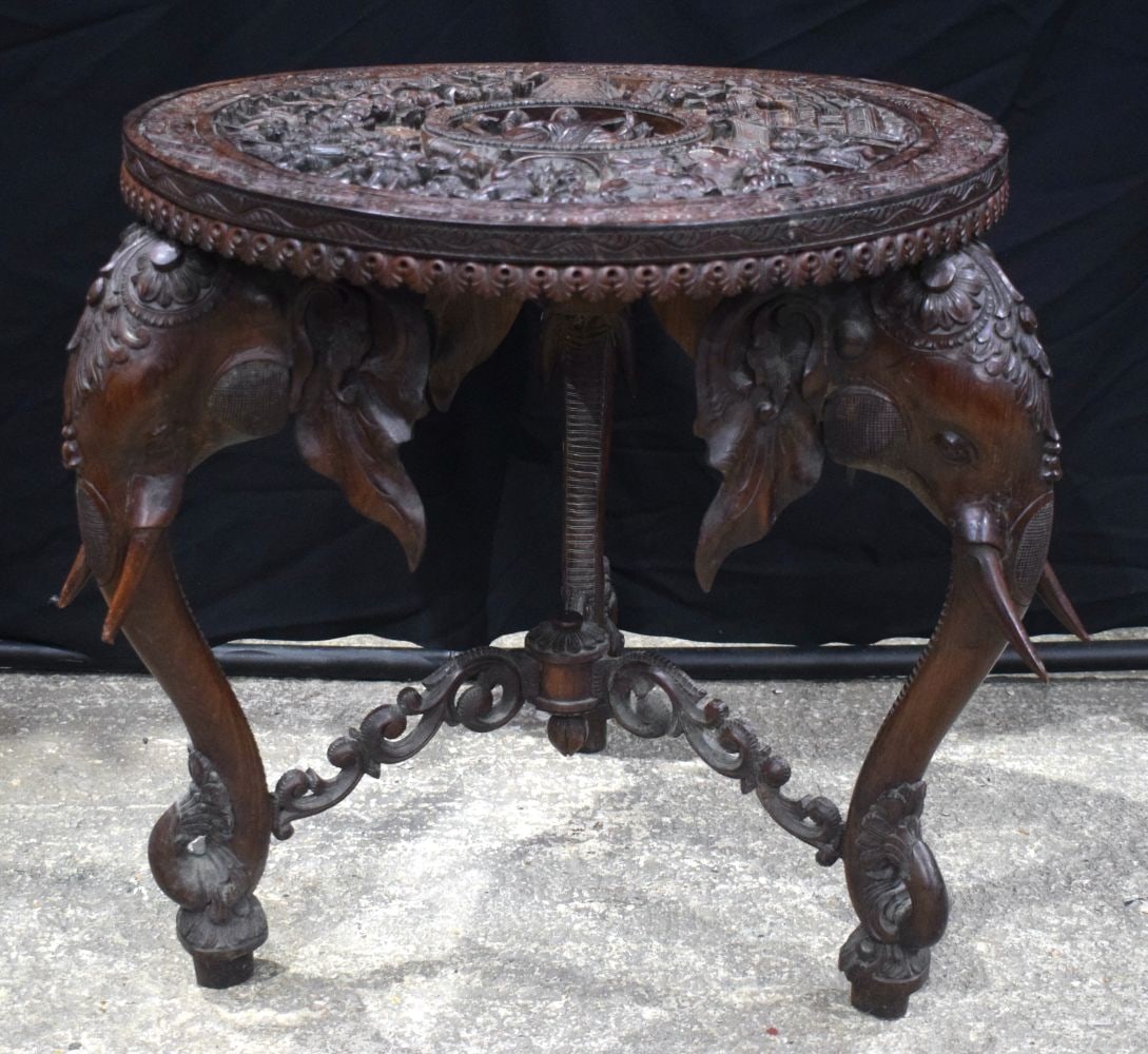 An Anglo Indian elaborately carved table with Elephant legs and figures carved to the top 64 x 63 (1 of 4)