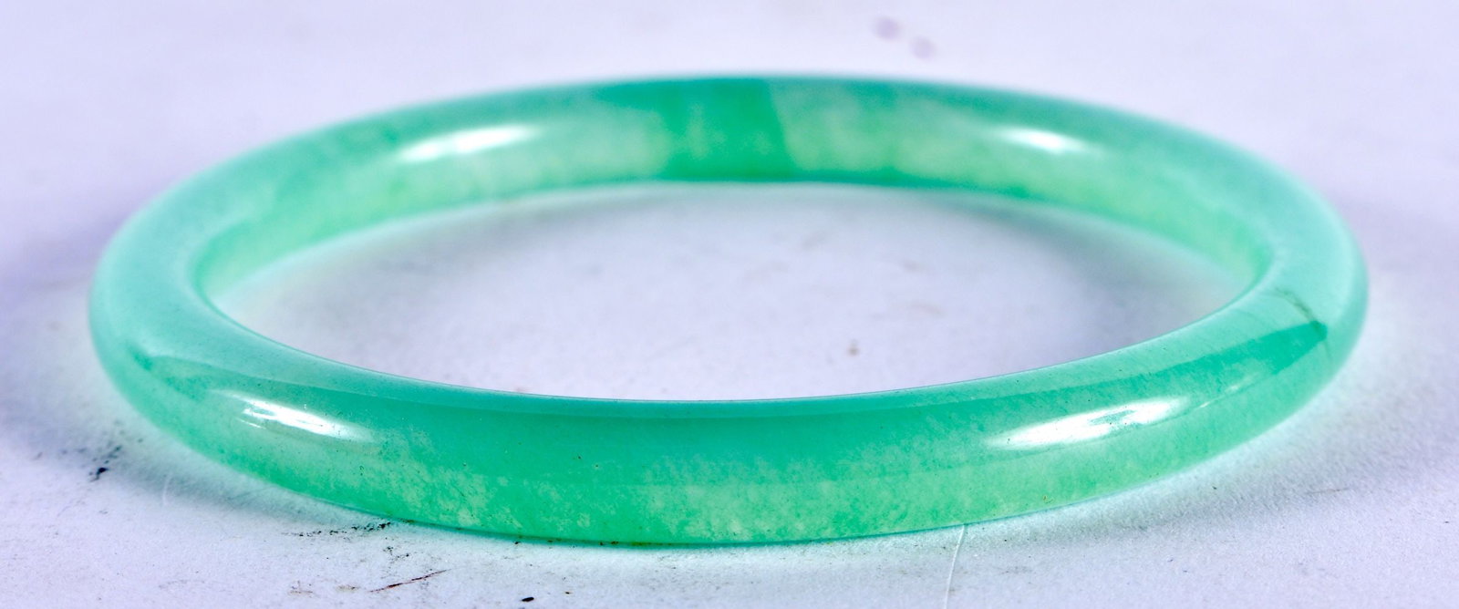 A CHINESE CARVED JADE BANGLE 20th Century. 30 grams. 6.5 cm diameter.: A CHINESE CARVED JADE BANGLE 20th Century. 30 grams. 6.5 cm diameter.