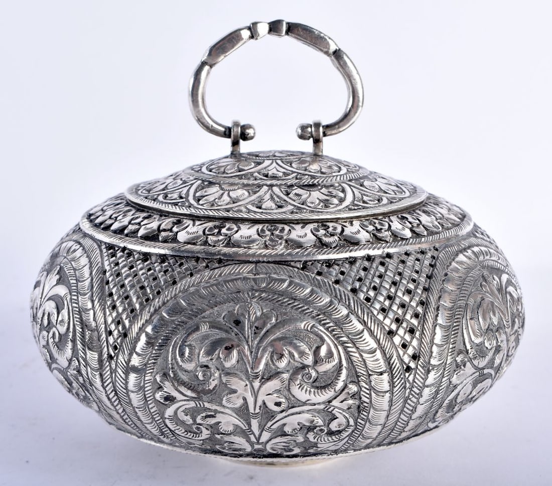 A LATE 19TH CENTURY INDIAN SILVER CIRCULAR TRAVELLING INCENSE BURNER AND COVER decorated with repous (1 of 6)