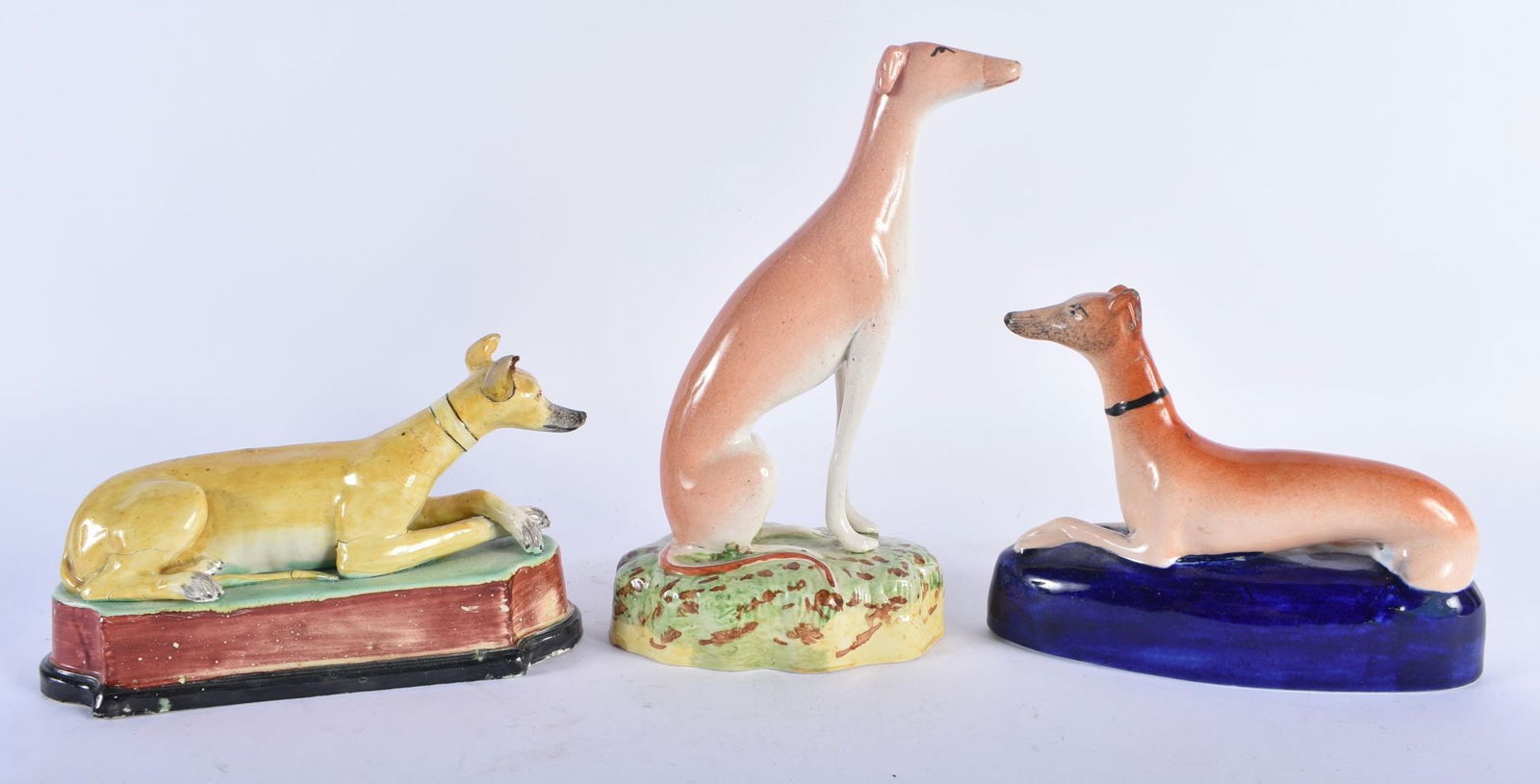 AN EARLY 19TH CENTURY STAFFORDSHIRE FIGURE OF A RECUMBENT HOUND Attributed to Enoch Wood, together w (1 of 5)