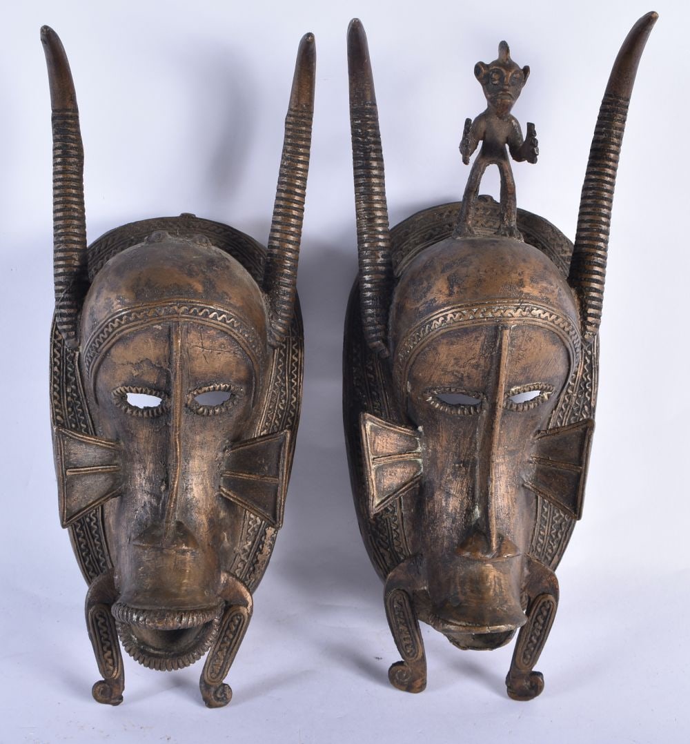 A PAIR OF AFRICAN BRONZE TRIBAL MASKS. 35 cm x 10 cm. (1 of 5)
