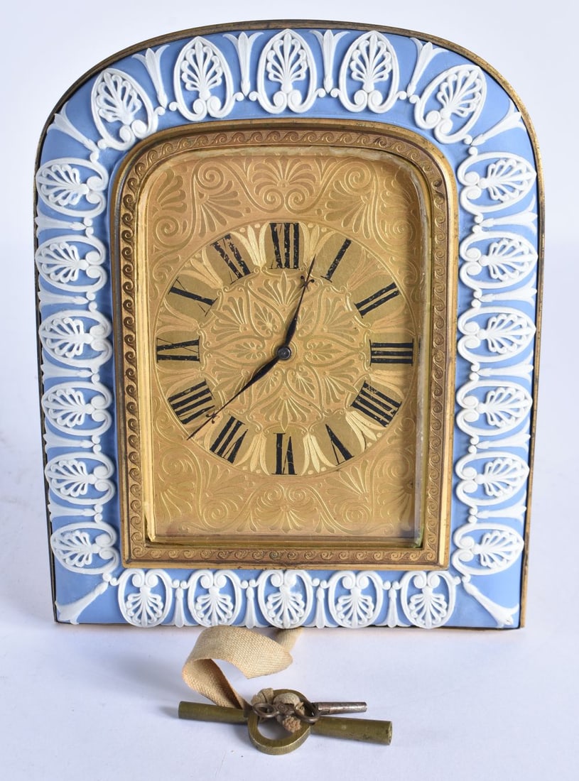 A RARE 19TH CENTURY ORMOLU AND WEDGWOOD PORCELAIN JASPERWARE CLOCK in the Manner of Thomas Cole, the: A RARE 19TH CENTURY ORMOLU AND WEDGWOOD PORCELAIN JASPERWARE CLOCK in the Manner of Thomas Cole, the dial decorated with flowing flowers. 18 cm x 14 cm.