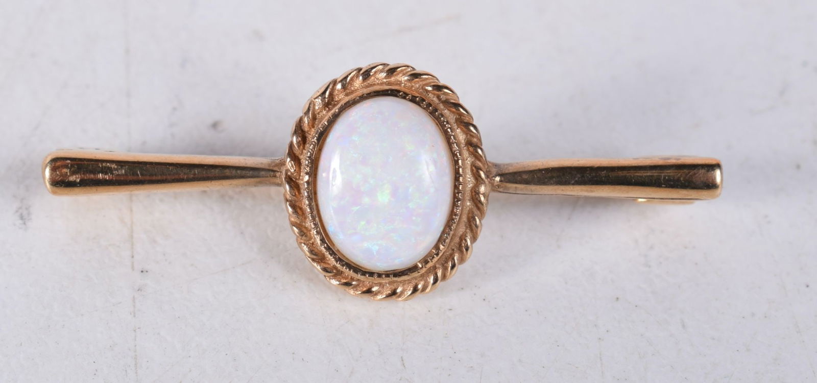 A 9CT GOLD AND OPAL BROOCH. 1.8 grams. 3 cm x 1 cm. (1 of 3)