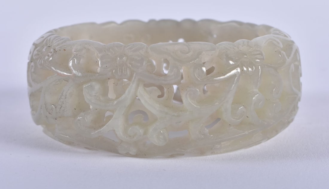 A CHINESE QING DYNASTY RETICULATED JADE BANGLE. 77 grams. 6 cm x 2.75 cm. (1 of 3)