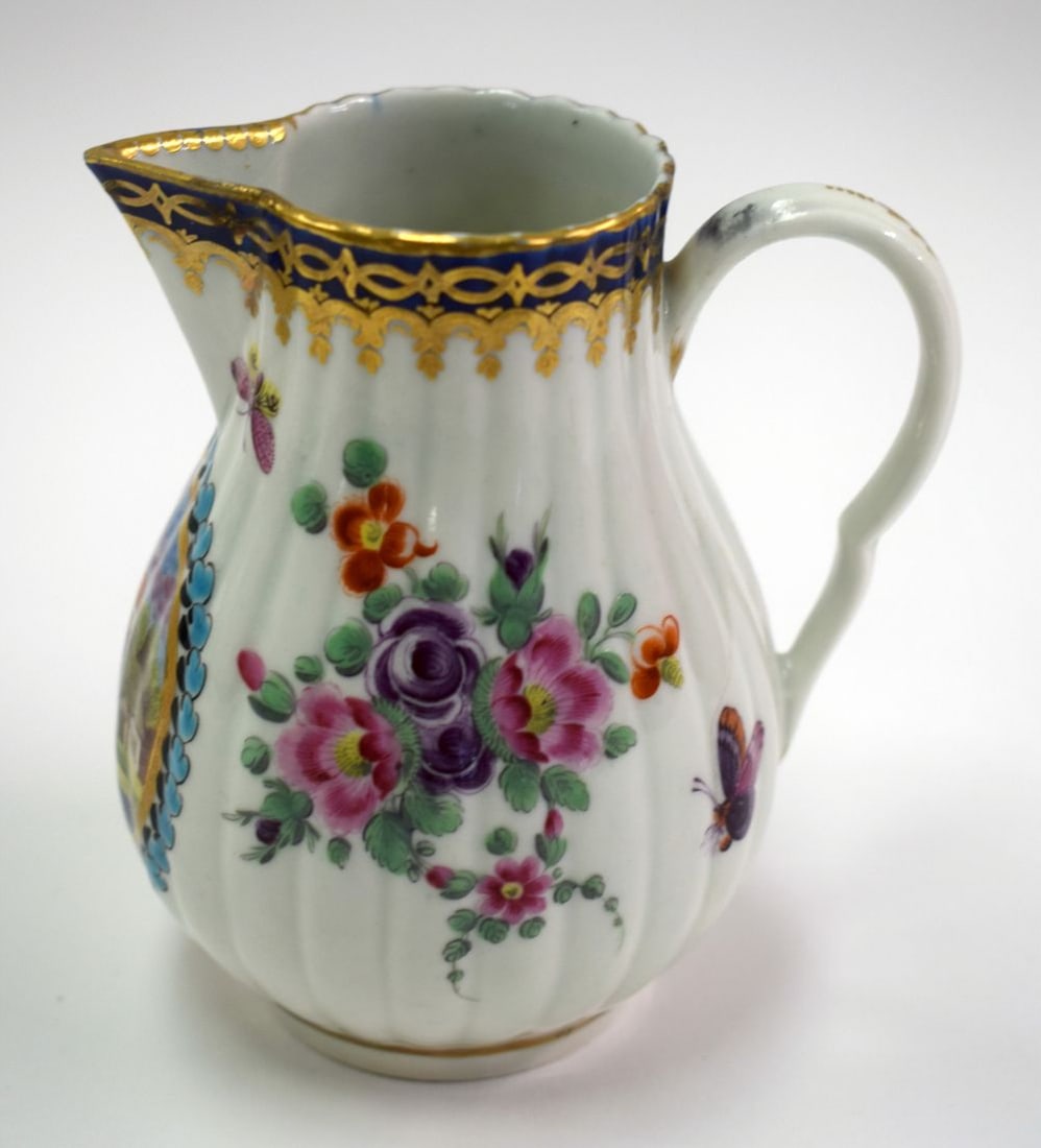 18th century Worcester fluted sparrowbeak jug painted with the Delhousie pattern having a landscape: 18th century Worcester fluted sparrowbeak jug painted with the Delhousie pattern having a landscape in a circular panel, scattered flowers and insects, all under a gilt and blue border. 11cm high