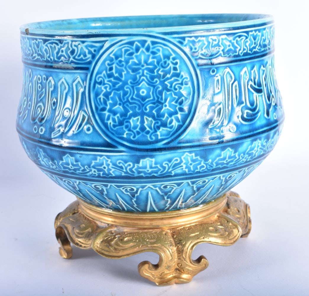 A 19TH CENTURY FRENCH ISLAMIC STYLE MOORISH FAIENCE BOWL by Theodore Deck, decorated in relief with: A 19TH CENTURY FRENCH ISLAMIC STYLE MOORISH FAIENCE BOWL by Theodore Deck, decorated in relief with foliage and scripture, upon a bronze base. 18 cm x 17 cm. Note: Joseph-Th?odore Deck (2 January 1823