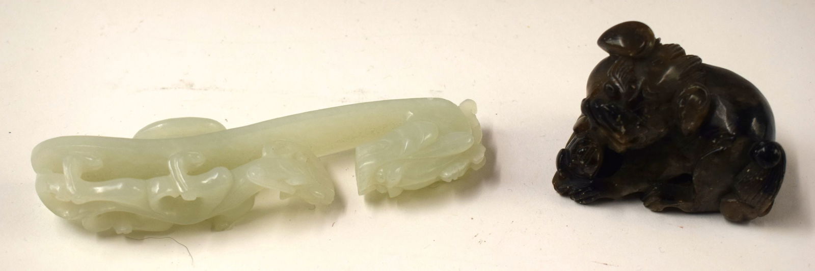 A 19TH CENTURY CHINESE CARVED GREENISH JADE BELT HOOK together with a stone beast. Largest 11cm wide (1 of 8)