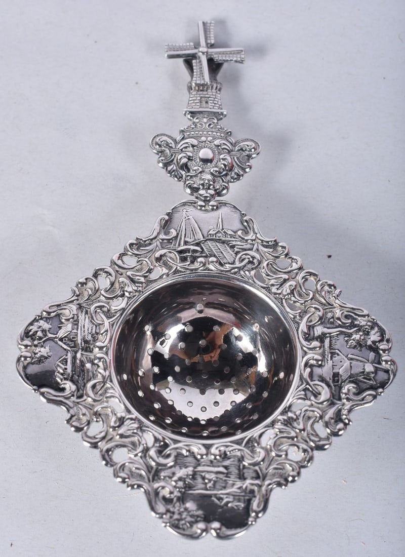 A Chinese Export Silver Tea Strainer with Dutch Style Embossed Decoration.  13.8cm x 8.2cm x 1.9cm, (1 of 3)