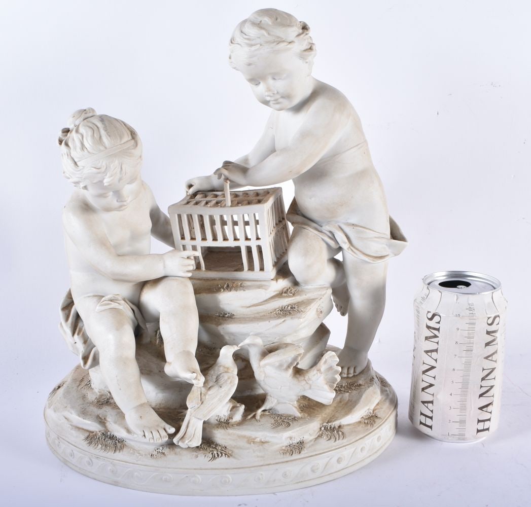 AN ANTIQUE FRENCH PARIAN WARE PORCELAIN FIGURAL GROUP modelled as a boy and girl beside a bird cage. (1 of 8)