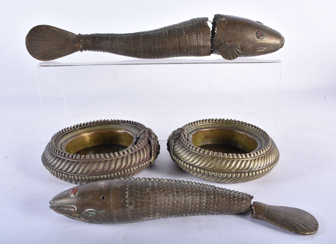 TWO EARLY INDIAN ARTICULATED FISH together with a converted pair of tribal cuff bangles. (4): TWO EARLY INDIAN ARTICULATED FISH together with a converted pair of tribal cuff bangles. (4)