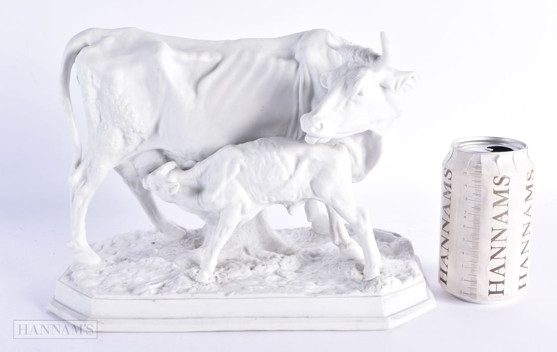 A 19TH CENTURY EUROPEAN PARIAN BISQUE PORCELAIN FIGURE OF A COW AND CALF modelled upon a naturalisti: A 19TH CENTURY EUROPEAN PARIAN BISQUE PORCELAIN FIGURE OF A COW AND CALF modelled upon a naturalistic base. 28 cm x 22 cm.