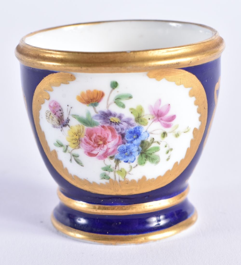 Sevres rare egg cup with cobalt blue ground painted with flowers in gilt panels Y mark for Bouilliat: Sevres rare egg cup with cobalt blue ground painted with flowers in gilt panels Y mark for Bouilliat, interlaced L?s, Sevres in script. 4.25 cm x 4.25 cm.