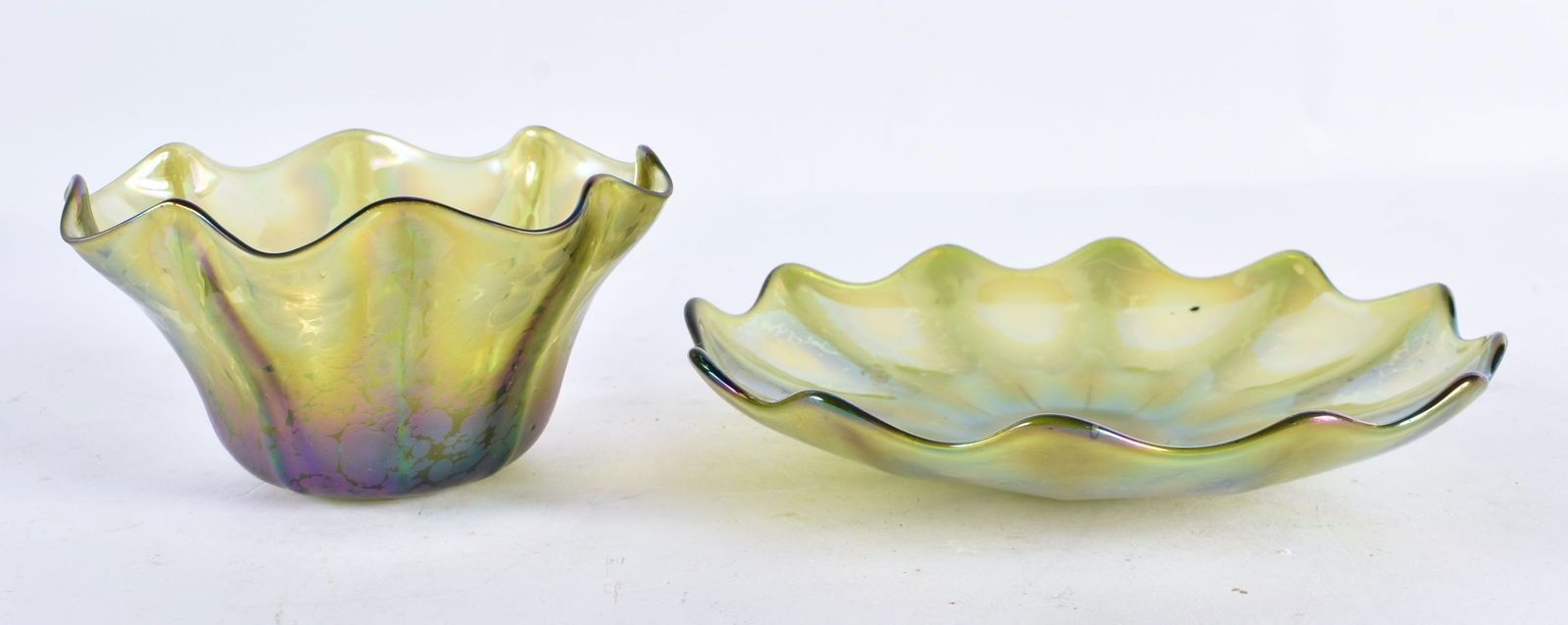 AN ART NOUVEAU AUSTRIAN GREEN GLASS BOWL possibly Loetz, together with a smaller bowl. Largest 17 cm: AN ART NOUVEAU AUSTRIAN GREEN GLASS BOWL possibly Loetz, together with a smaller bowl. Largest 17 cm wide. (2)