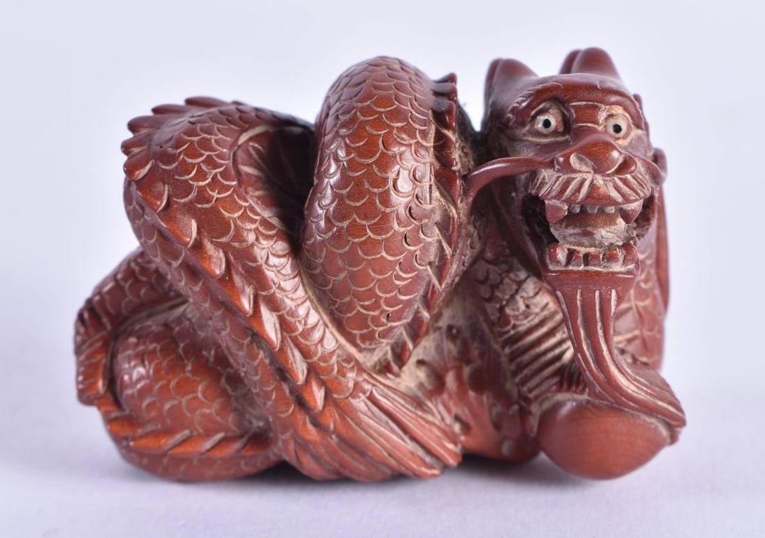 A JAPANESE CARVED WOOD DRAGON NETSUKE. 5.75 cm x 4 cm. (1 of 5)