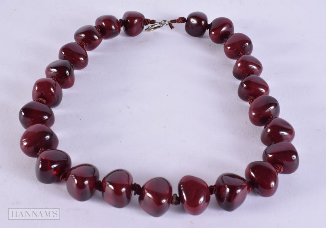 A CHERRY BEAD BOULDER NECKLACE possibly amber. 87 grams. 44 cm long, each bead 1.75 cm x 1 cm.: A CHERRY BEAD BOULDER NECKLACE possibly amber. 87 grams. 44 cm long, each bead 1.75 cm x 1 cm.