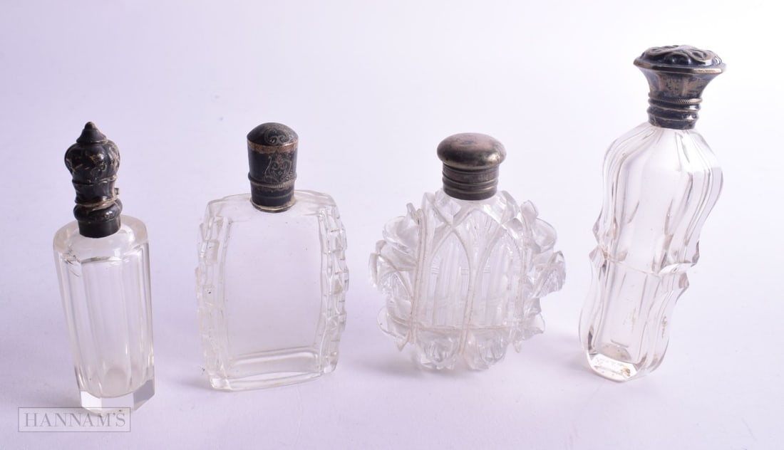FOUR ANTIQUE SILVER MOUNTED SCENT BOTTLE. 299 grams overall. Largest 11.25cm high. (4) (1 of 3)