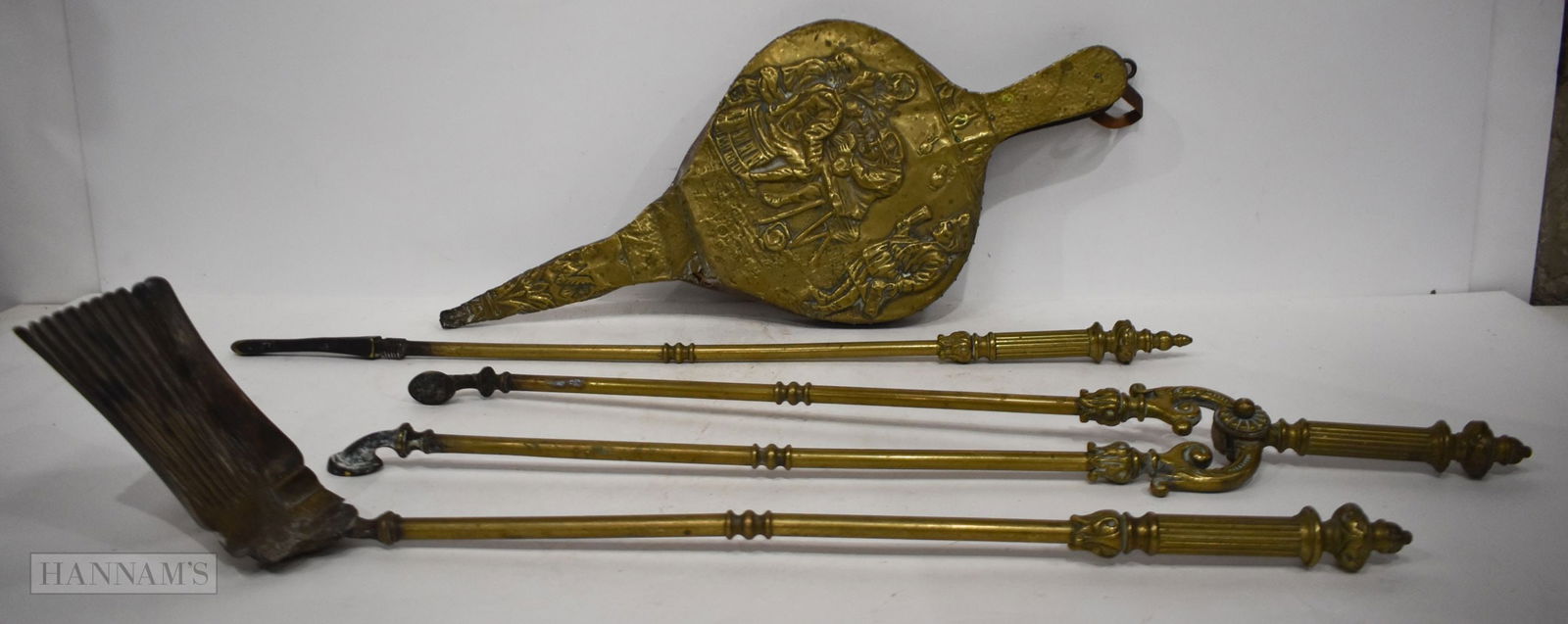 A SET OF VICTORIAN BRASS FIRE IRONS and a pair of embossed bellows. (4) longest 72cm: A SET OF VICTORIAN BRASS FIRE IRONS and a pair of embossed bellows. (4) longest 72cm