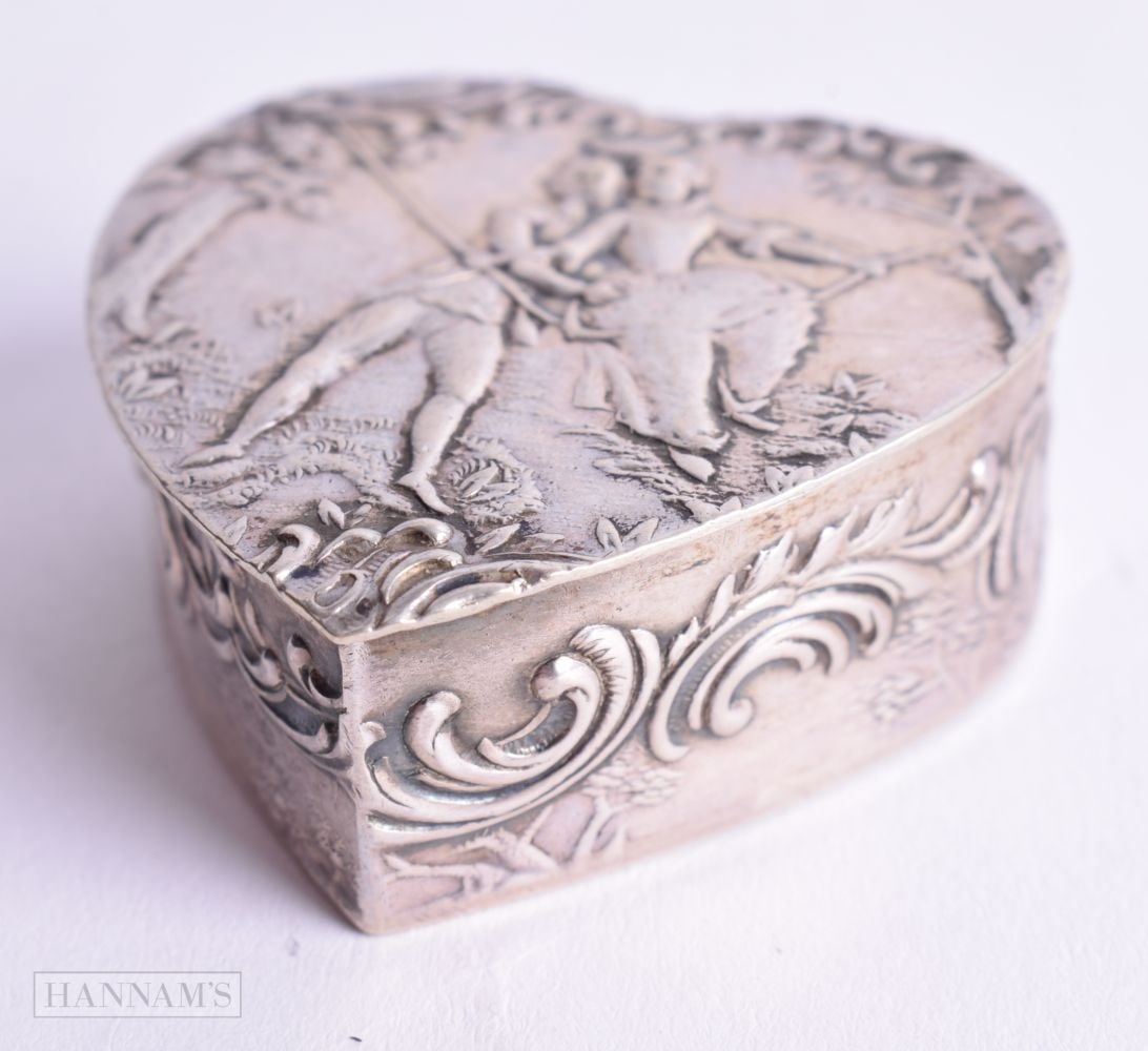 A CONTINENTAL SILVER HEART SHAPED PILL BOX WITH EMBOSSED DECORATION. Stamped 800. 4.2cm x 4.2cm x: A CONTINENTAL SILVER HEART SHAPED PILL BOX WITH EMBOSSED DECORATION. Stamped 800. 4.2cm x 4.2cm x 1.7cm, weight 28.2g