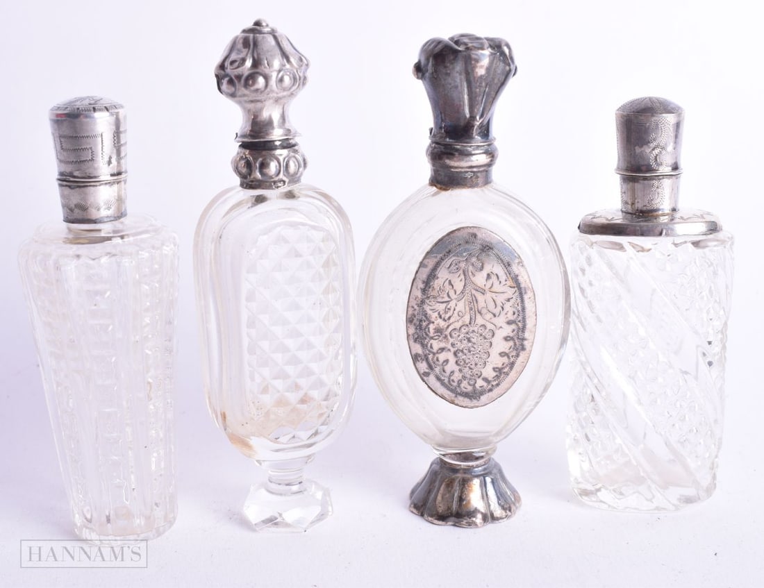 FOUR ANTIQUE SILVER MOUNTED SCENT BOTTLES. 179 grams. Largest 10.25 cm high. (4) (1 of 5)