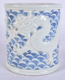 A CHINESE BLUE AND WHITE PORCELAIN DRAGON BRUSH POT. 12 cm high.: A CHINESE BLUE AND WHITE PORCELAIN DRAGON BRUSH POT. 12 cm high.