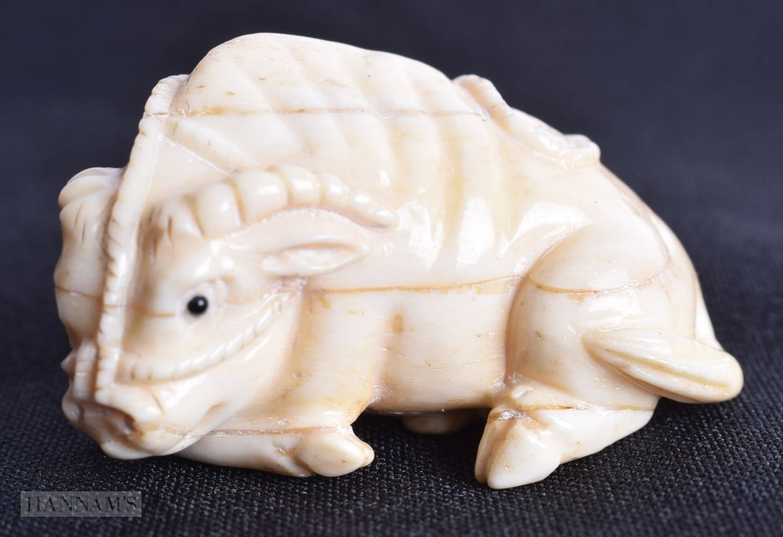 A JAPANESE CARVED BONE BULL NETSUKE. 28.8 grams. 4.75 cm x 2.75 cm.: A JAPANESE CARVED BONE BULL NETSUKE. 28.8 grams. 4.75 cm x 2.75 cm.