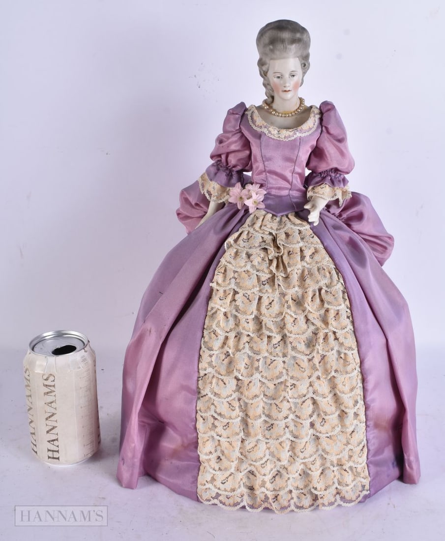 A LARGE ANTIQUE BISQUE HEADED PORCELAIN DOLL TEA COSY. 40 cm x 22 cm.: A LARGE ANTIQUE BISQUE HEADED PORCELAIN DOLL TEA COSY. 40 cm x 22 cm.